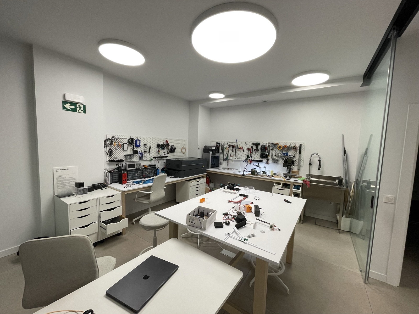Mesa de trabajo con prototipos, electrónica y herramientas